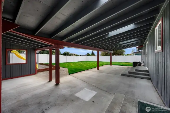 This covered patio is incredible! So many different ways to use and make your own for year around enjoyment. Two access points from inside home- off the dining area and from the utility room. Large outbuilding to the left provides additional storage, potting shed or even a workshop!