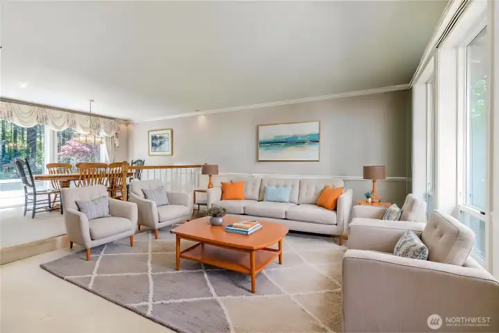 Seamlessly connected formal living and dining rooms with timeless wainscoting, crown molding, and oversized windows that frame picturesque views of both the front and back yards. Seamlessly connected formal living and dining rooms with timeless wainscoting, crown molding, and oversized windows that frame picturesque views of both the front and back yards.