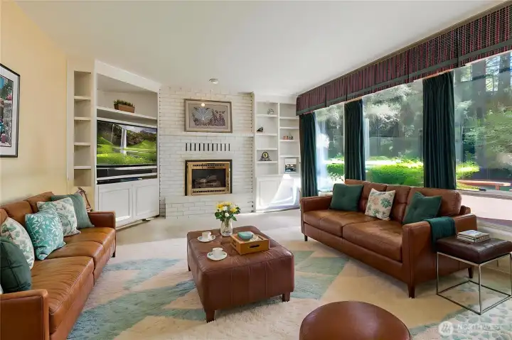 This sun-filled family room boasts extensive built-ins, a classic white brick fireplace, and massive windows that bring the beauty of the outdoors in. This sun-filled family room boasts extensive built-ins, a classic white brick fireplace, and massive windows that bring the beauty of the outdoors in.
