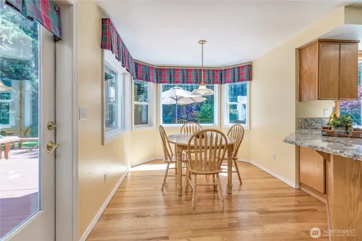 Inviting breakfast nook with a sunny bay window and deck access, ideally situated for casual daily dining with views of the park-like grounds.