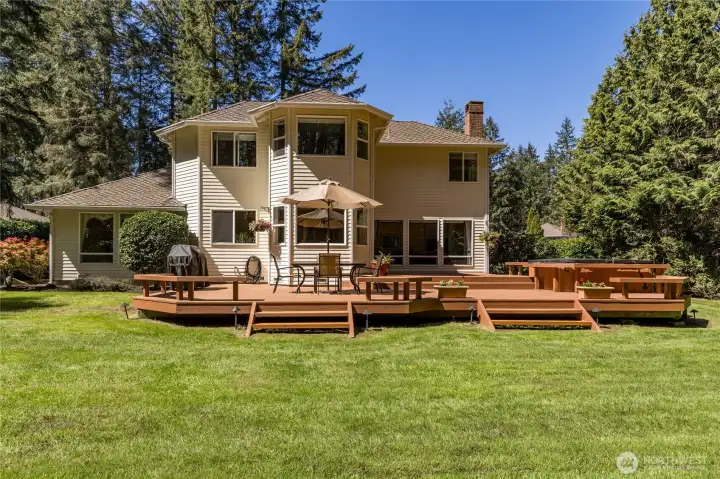 Large multi-tier deck with integrated bench seating overlooks the private backyard, the ultimate space for outdoor relaxation and gatherings.