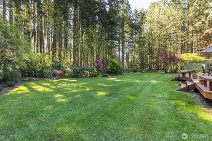 The expansive, level lawn offers endless possibilities for play, gardening, or hosting large outdoor events.