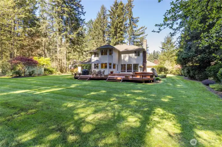 Rear exterior view showcasing the home’s grand scale and its connection to the massive, level backyard - perfectly maintained and ready for outdoor enjoyment.
