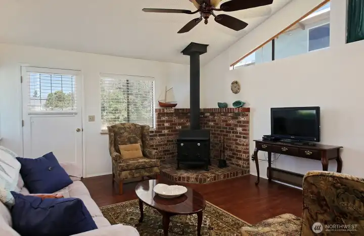 The wood stove provides plenty of heat and is the perfect place to cozy up on chilly venings. Door to the left leads to the North side of your home. The wood stove provides plenty of heat and is the perfect place to cozy up on chilly venings. Door to the left leads to the North side of your home.