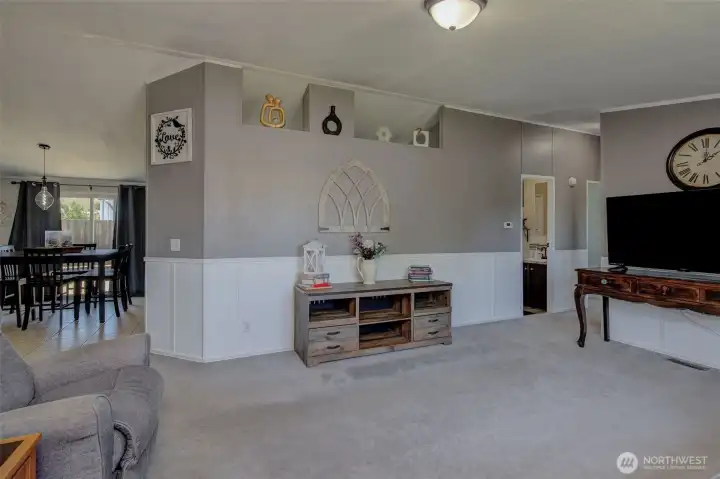 Living Room is warmly painted with nice wainscot and built-in display ledges. Hallway leads toward 2 beds and a bath.