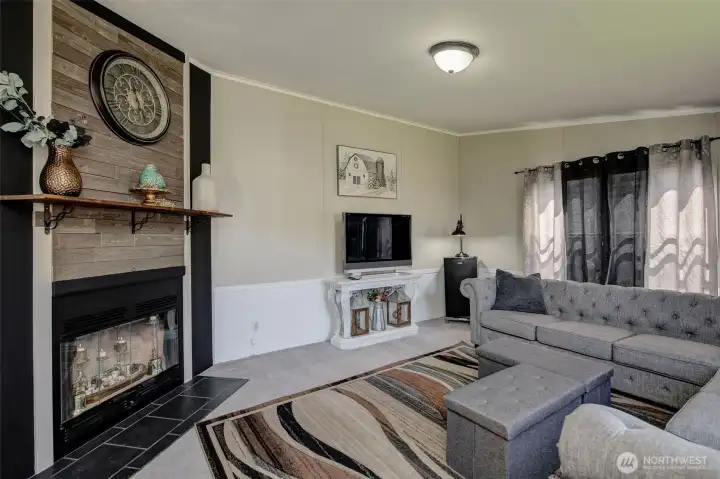 Family Room offers a cozy wood fireplace, warm colors, pretty wainscot and plenty of space for gatherings!