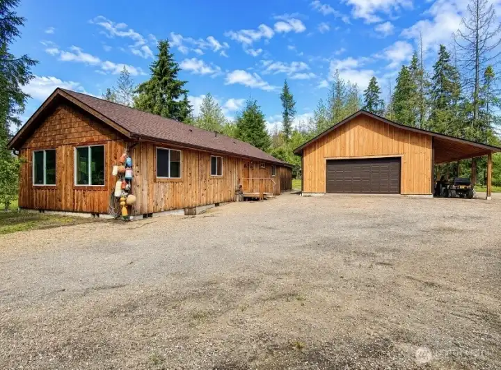 Front view of home with detached garage and expansive parking area. Front view of home with detached garage and expansive parking area.