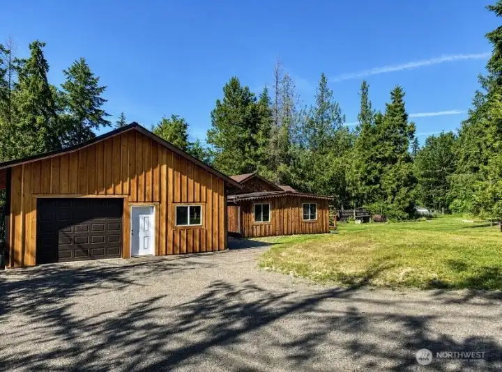 Rear view of the home and oversized garage showcasing the spacious backyard setting. Rear view of the home and oversized garage showcasing the spacious backyard setting.