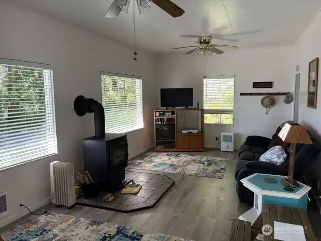 Spacious living room with newer wood burning fireplace, ceiling fans and the possibility for multi conversation areas.