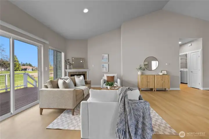 Spacious living room with vaulted ceiling, recessed lighting, and fireplace as focal point