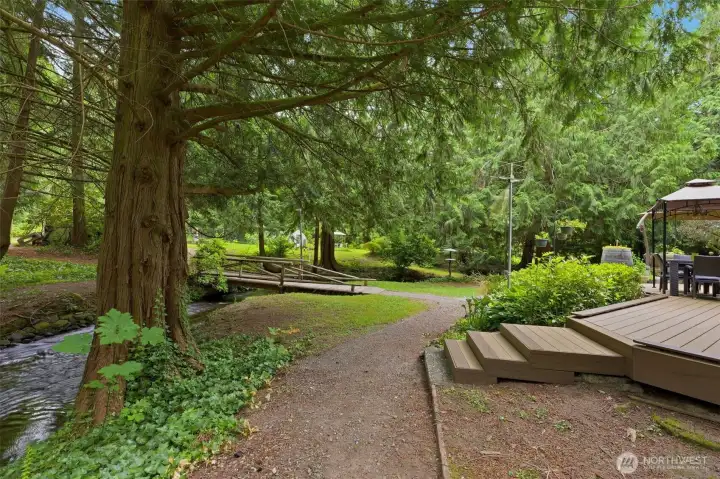 Relax on the newer composite deck overlooking the lawn and the tranquil creek below. Relax on the newer composite deck overlooking the lawn and the tranquil creek below.