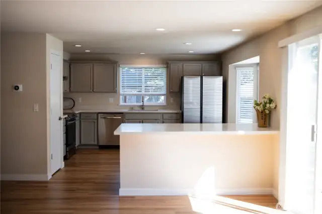 Shining Quartz Countertops and a large Breakfast Bar/Peninsula seen from the family room