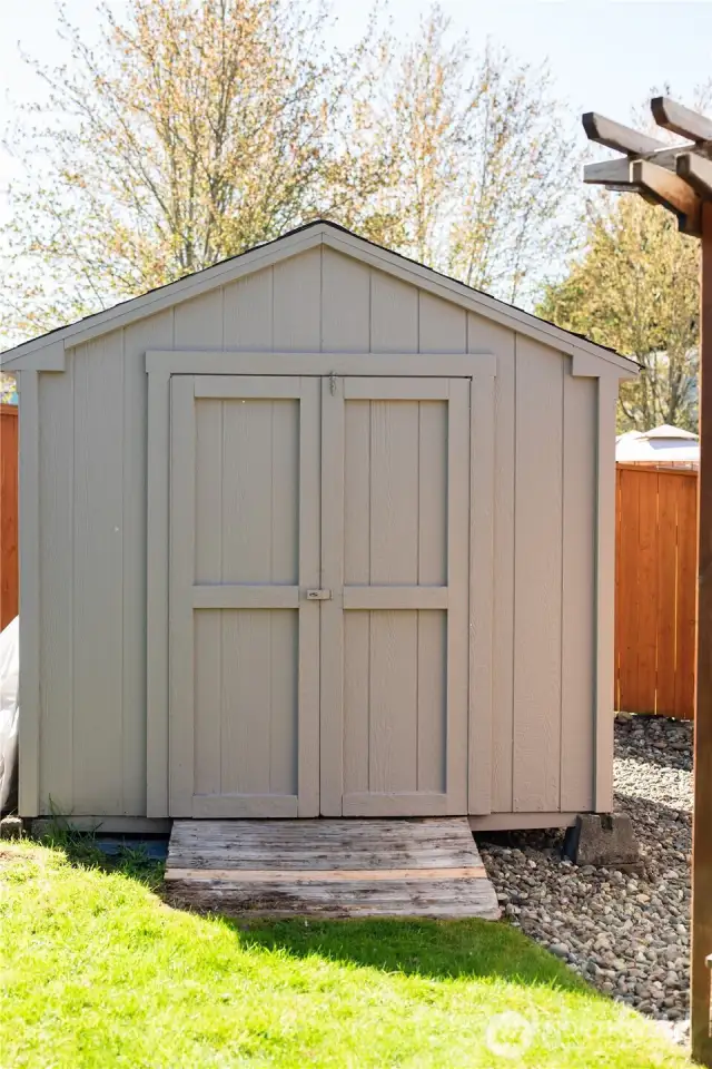 Shed in backyard is perfect for lawn mower and other garden tools