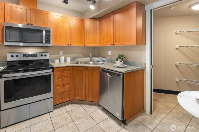 Kitchen with ample cabinet storage, featuring easy access to spacious pantry.