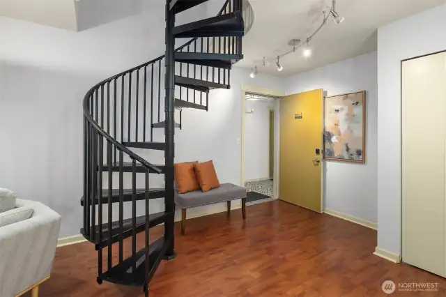 Front door opening to living space featuring spiral staircase to upper level.