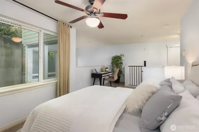 Bedroom featuring large windows and flow into upper living space.
