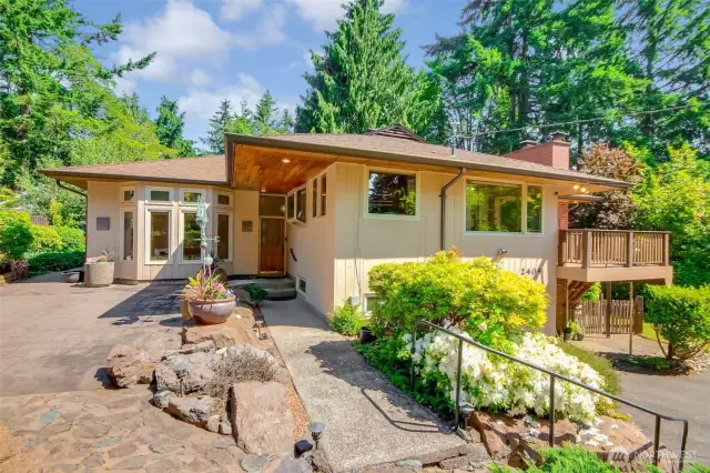 Welcoming front approach with stamped concrete patio and tiered beds.
