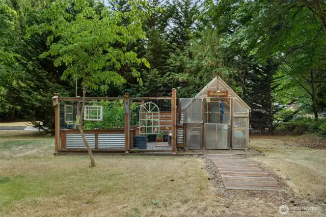 Enclosed greenhouse and garden with a sink and running water.