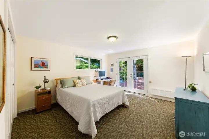 Bedroom #1 on the main level, south side of the house, with walk-out double-doors to the expansive upper deck.