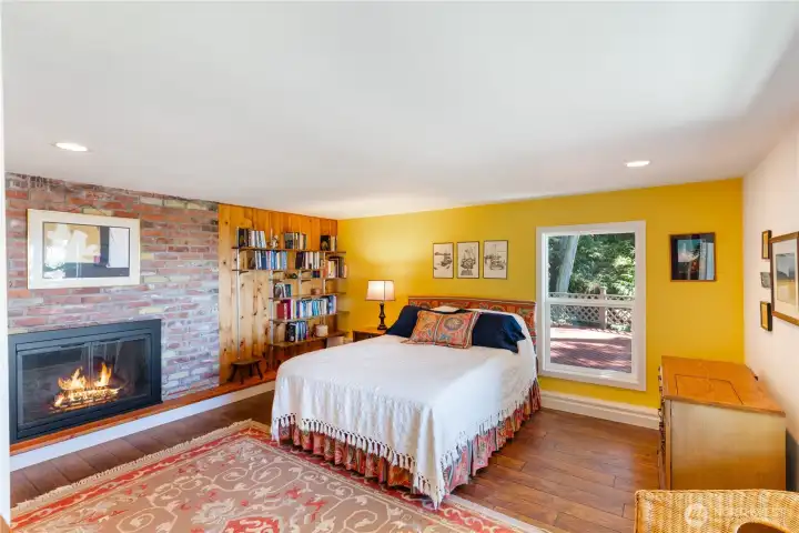 Bedroom #3 on the lower level. It has a wood burning fireplace also, and a window out onto the lower level deck and west to the water.