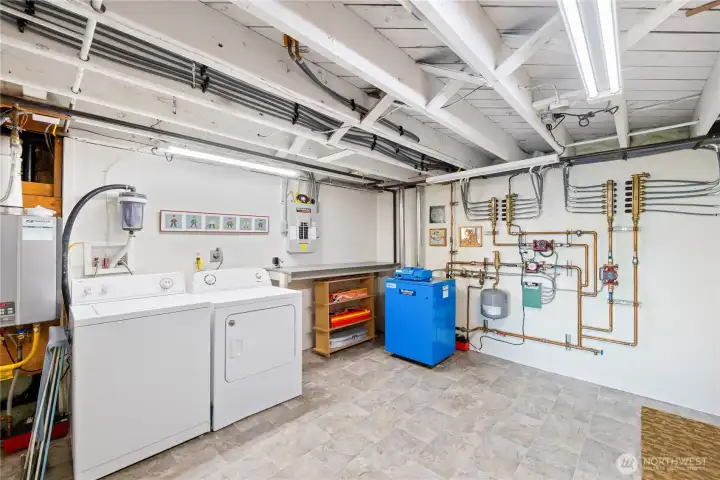Utility room with washer/dryer, on-demand water heater, boiler and radiant heat system.