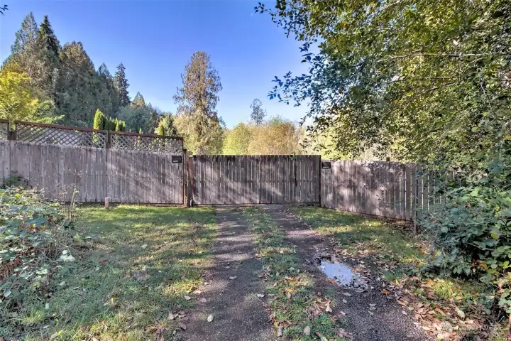 The approach to the property from the shared driveway. That large gate has a roller on the bottom of it to get it open.