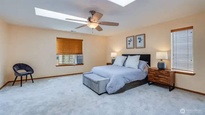 Walk into this beautiful primary bedroom, where natural light pours in through skylights, creating a bright and airy retreat