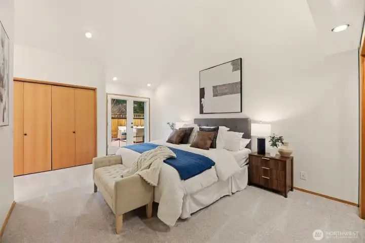 Primary suite offers dual closets, updated 5-piece ensuite with heated tile floor, direct access to the backyard and hot tub.