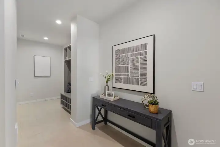 Welcoming entryway with soaring ceilings, abundant natural light, and thoughtfully designed built in mudroom storage creating both style and everyday functionality.