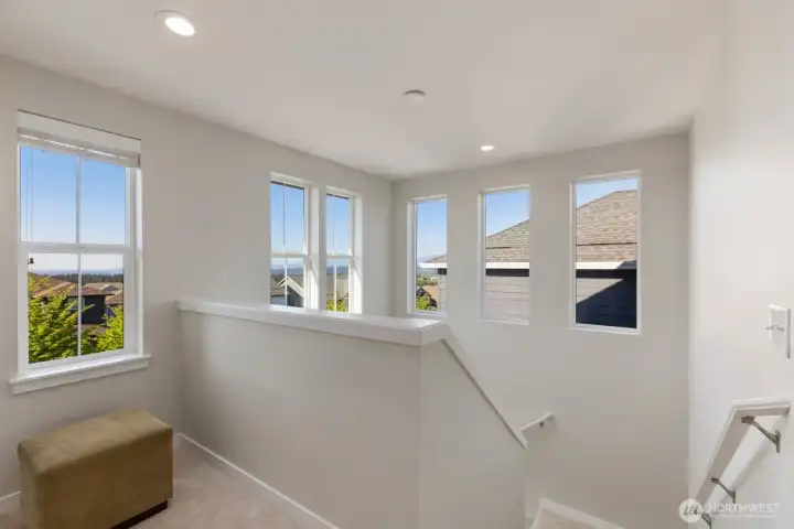 The upper level is lined with beautiful windows that capture sweeping mountain views and abundant natural light, while an inviting alcove to the left offers the perfect space for a writing desk, quiet reading retreat, or peaceful morning escape.