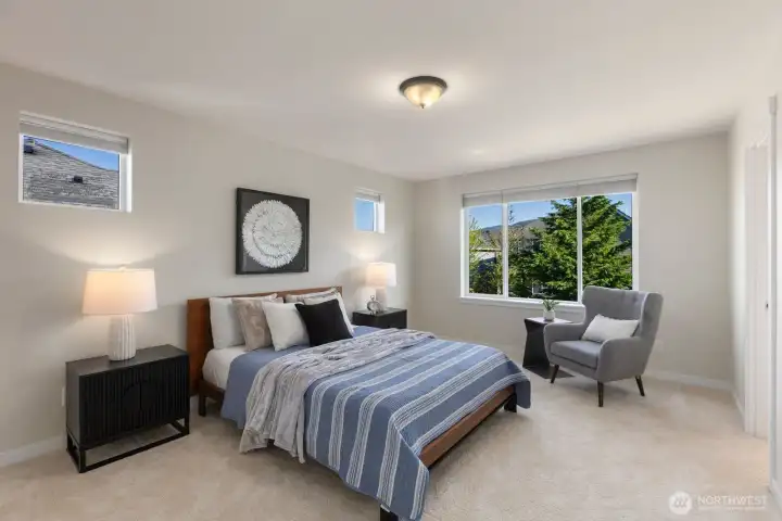 Light filled primary bedroom offering a peaceful retreat with soft natural light, mountain outlooks, plush new carpet, and blackout blinds designed for restful comfort.