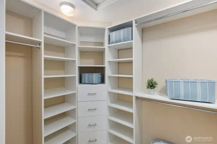 Well appointed custom designed primary closet with thoughtfully integrated storage and organization