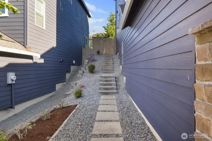 Thoughtfully landscaped side yard with custom terraced stairs providing convenient access to the backyard while enhancing functionality and ease of maintenance.