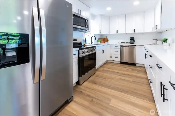 Crisp white cabinetry, stainless appliances, and a clean tile backsplash make this kitchen as functional as it looks.