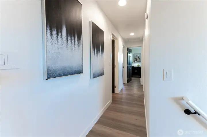 Wide, light-filled hallway leads to all three bedrooms and the main floor bath.