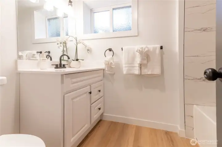 Lower level full bath with updated vanity, marble-style tile surround, and its own private feel.
