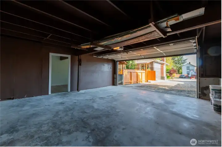 Garage opens directly to the gravel driveway. Bonus room door visible at left, connected but separate.