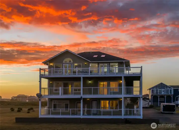 the Three Level home lights up at night under the Ocean's Painted Skies!