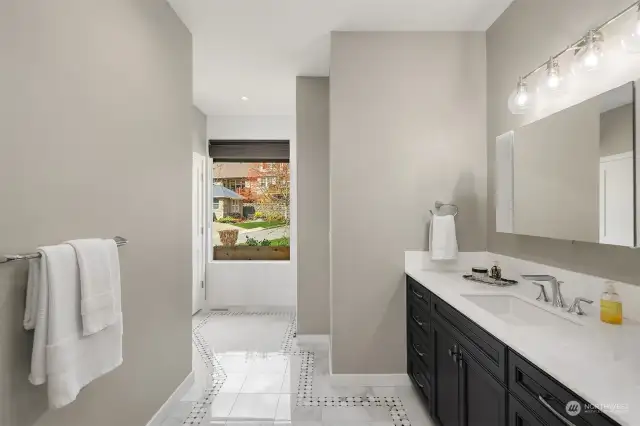 A luxurious ensuite bathroom off the first primary bedroom. Enjoy heated floors every morning.