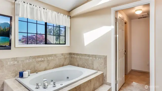 Large jetted tub surrounded by classic toned tile.