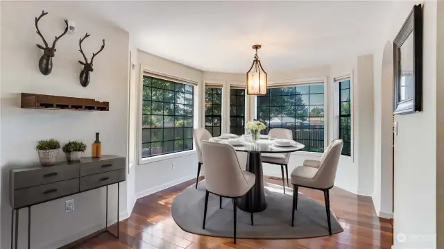 Formal dining room with more of the hardwoods and ample amount of light that beams in through the surrounding windows. **virtually staged**