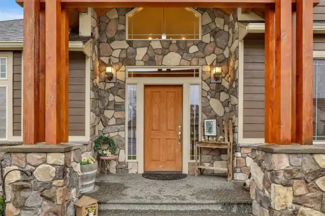 A rich palette of natural elements--stone accents, paired with wood beams & natural shingles in earthy tones create a lodge ambiance to this stunning home.