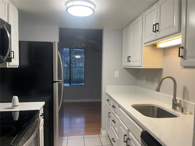 Quartz counters stainless appliances white cabinets