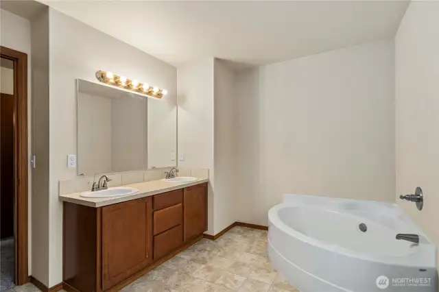 Primary bathroom with a 5-piece layout, including a soaking tub and dual sinks.