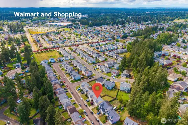 The aerial photo highlights the convenience of nearby shopping and restaurants.
