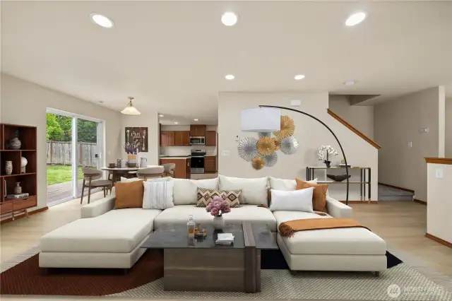 The inviting living room, featuring a cozy gas fireplace, seamlessly flows into the dining area and kitchen—creating a warm and open space perfect for gatherings and everyday living