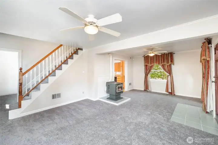 Living room features new carpet, ceiling fans, large windows and fireplace.