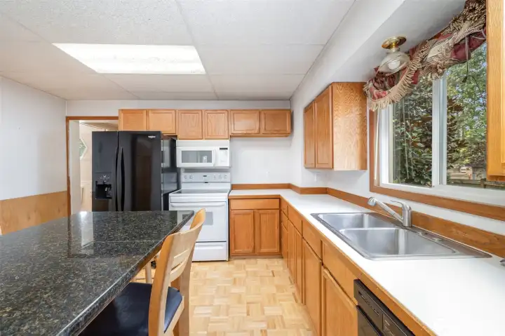 Another view of the kitchen showcasing all the cabinet storage and counter space. Don't forget the large window above the sink!