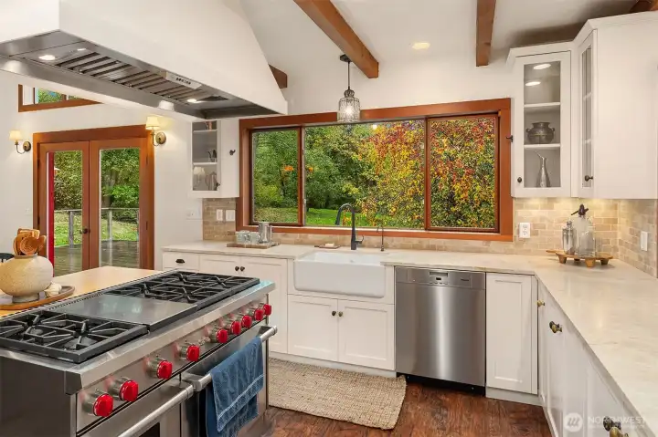 Quality meets romance in the kitchen: The classic farm sink and cottage style cabinetry seamlessly blend with the 6 burner gas range, Wolf double oven, Miele Dishwasher, and Liebherr refrigerator.