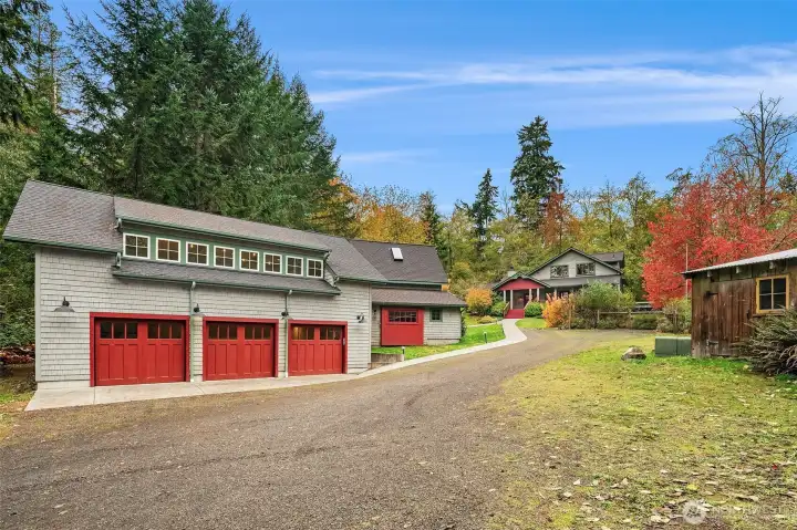 Expansive three car garage for cars, yes—or cool toys and extra storage. To the left, a quaint barnlet currently housing firewood.